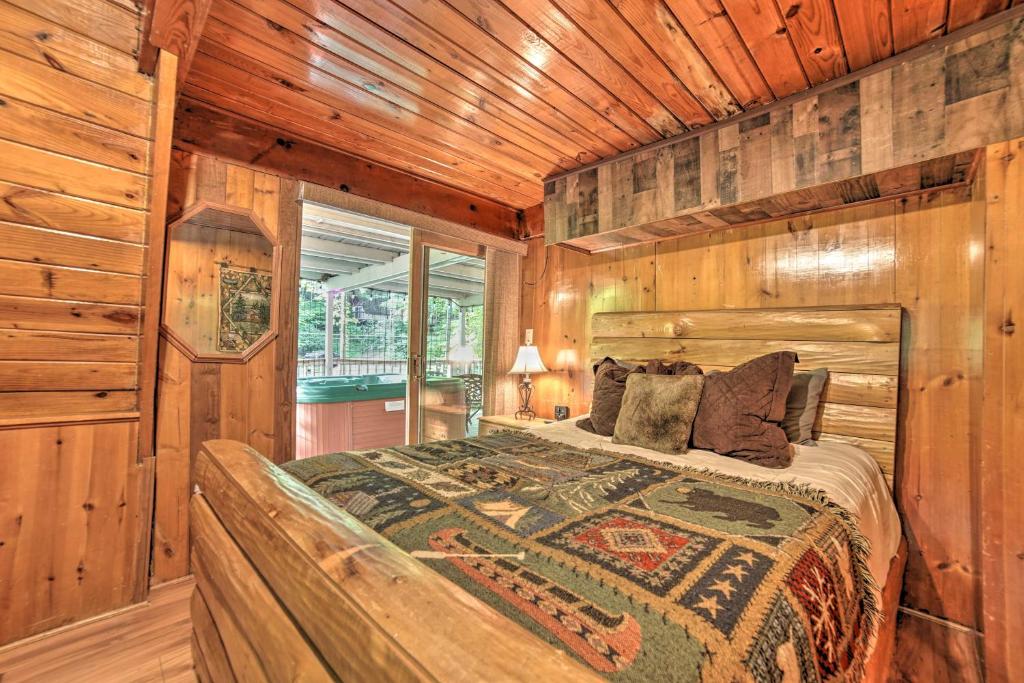 A log-frame bed with the hot tub just beyond the slider · © The Green-Roof A-Frame