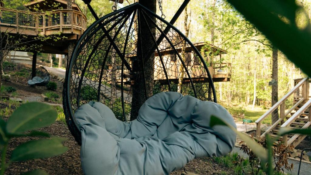 A hanging egg chair in the grove between treehouses · © The Magnolia at Treehouse Grove