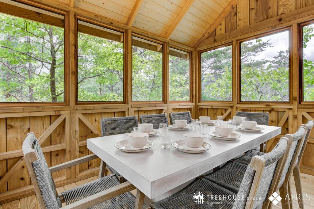 The long dining table on the screened porch · © The Moosewood at Treehouse Grove