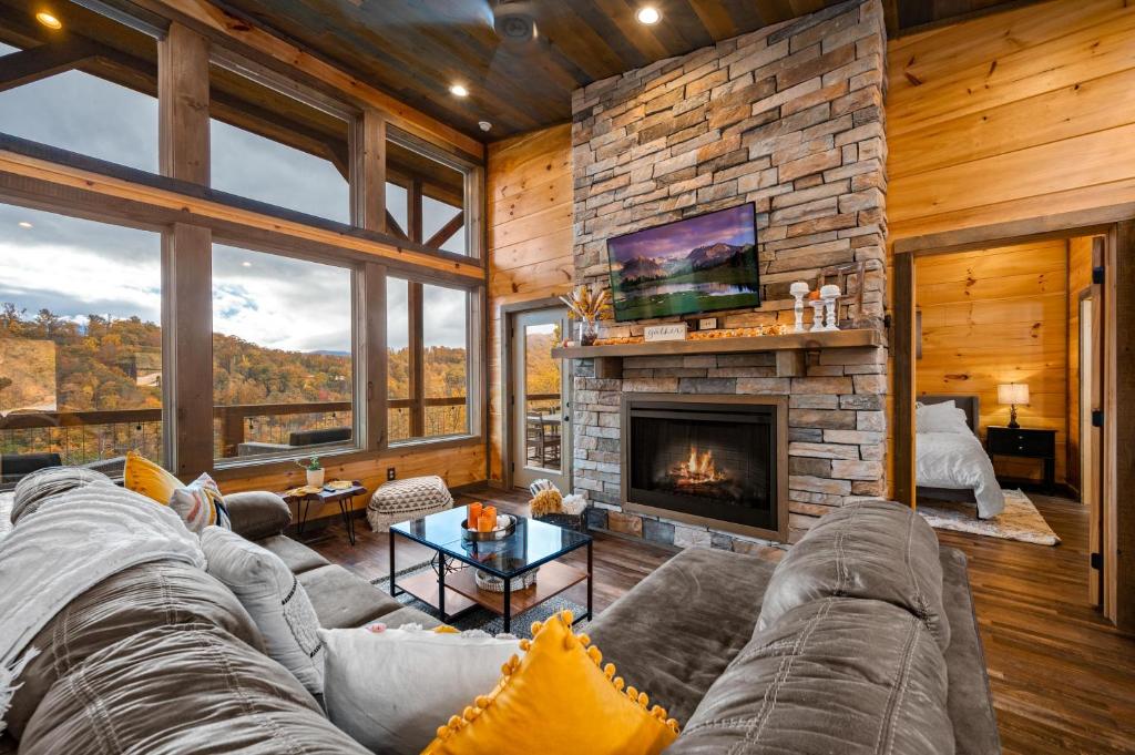The living room's stone fireplace and tall view windows · © The Overlook
