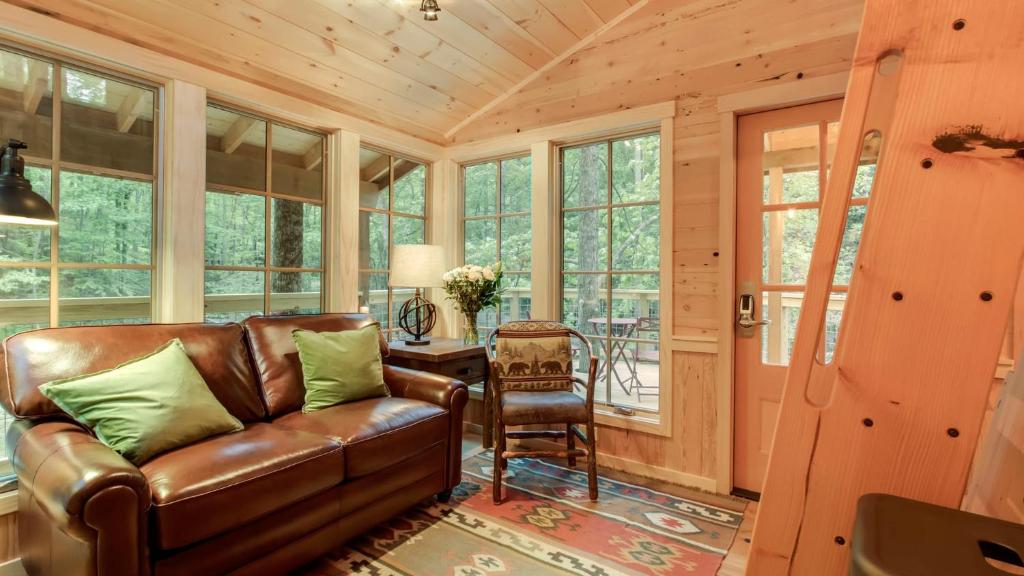 The leather sofa under a vaulted wood ceiling · © The Poplar at Treehouse Grove