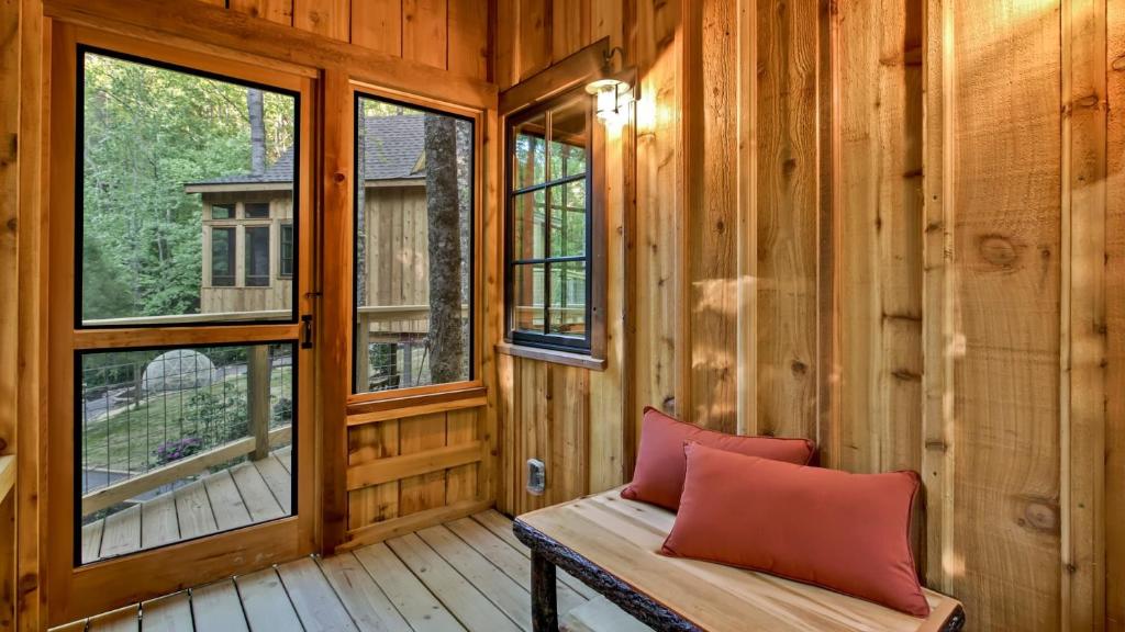 A cushioned bench in the screened porch · © The Poplar at Treehouse Grove