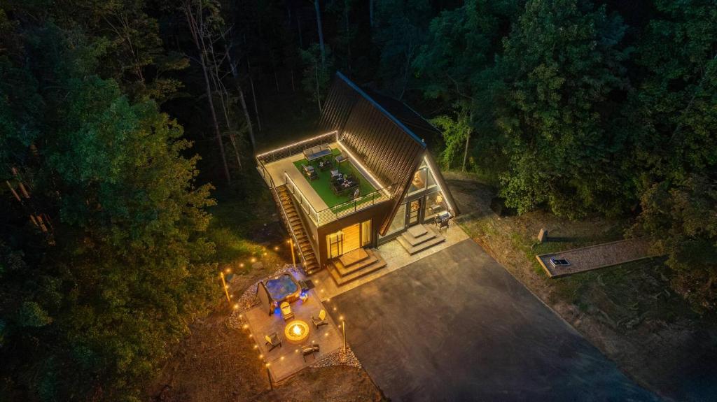 The A-frame from above, with the lit rooftop deck and the patio · © The Sleek Covemont A-Frame