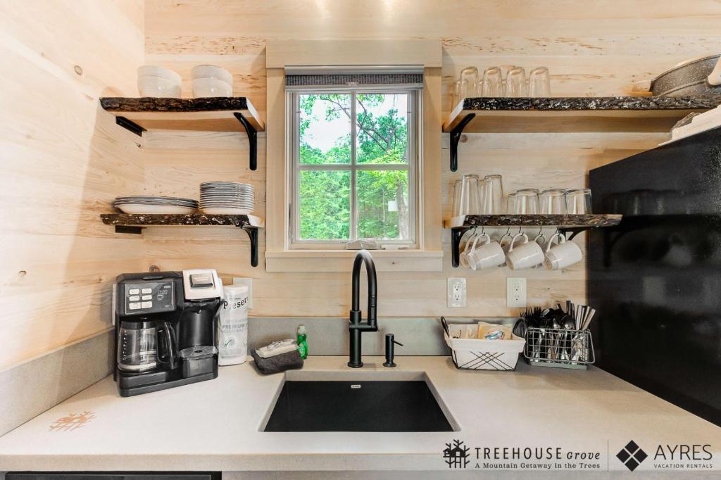 Live-edge shelves above the kitchen sink · © The Spruce at Treehouse Grove