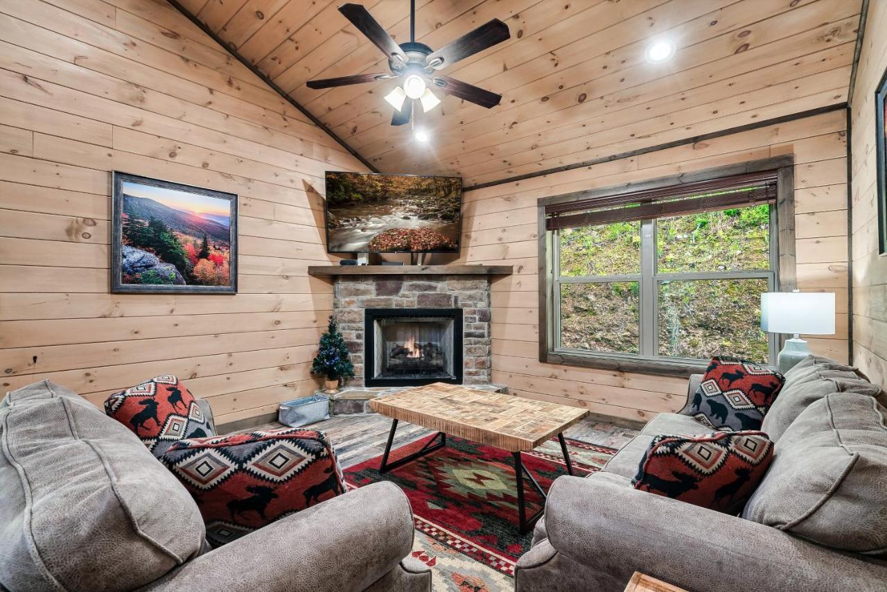 The living room's stone gas fireplace under a vaulted pine ceiling · © The Wacky Woodpecker