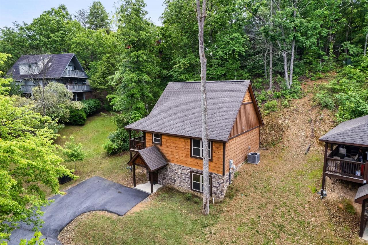 The cabin set into its wooded Pigeon Forge hillside · © The Wacky Woodpecker
