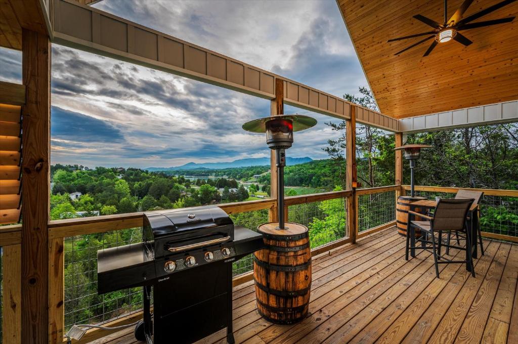 The wrap-around covered deck with a gas grill and valley view · © Tennessee Whiskey Cabin