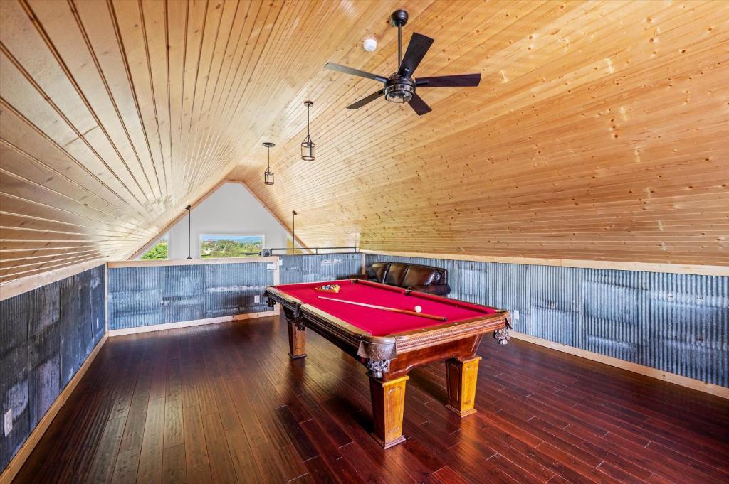 The loft game room with a full-size pool table under a pine ceiling · © Tennessee Whiskey Cabin