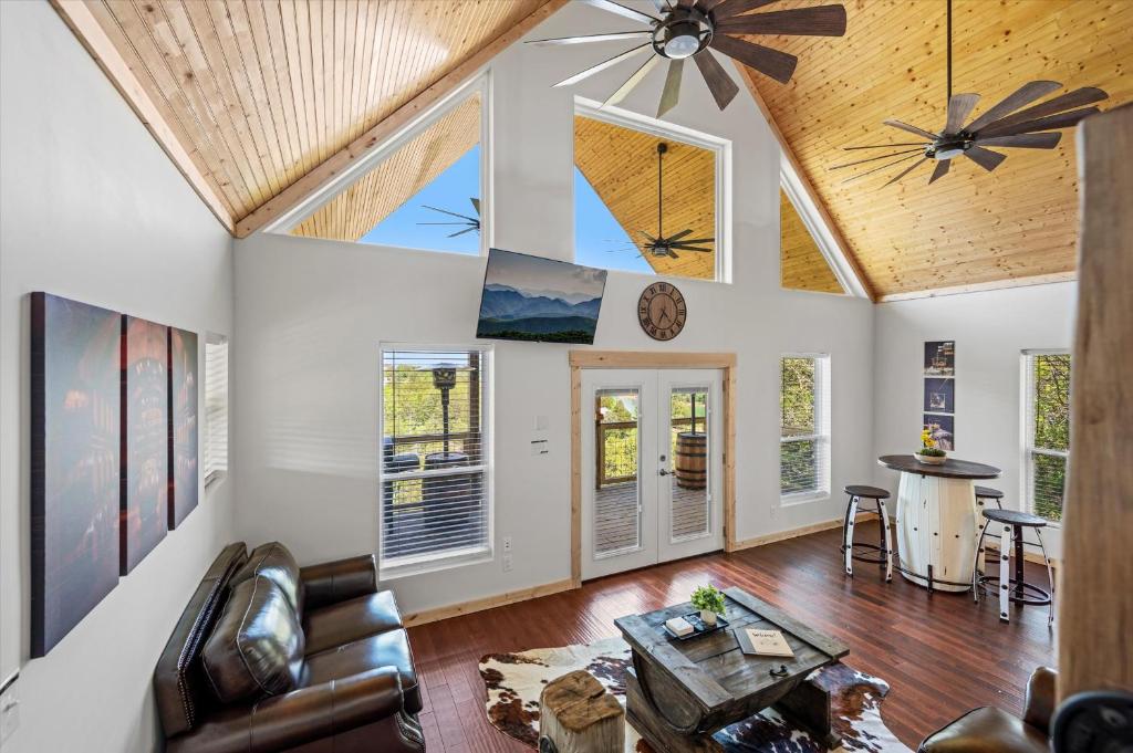 The vaulted great room and its gable wall of windows · © Tennessee Whiskey Cabin