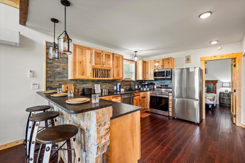 The kitchen with hickory cabinets and a stone breakfast bar · © Tennessee Whiskey Cabin