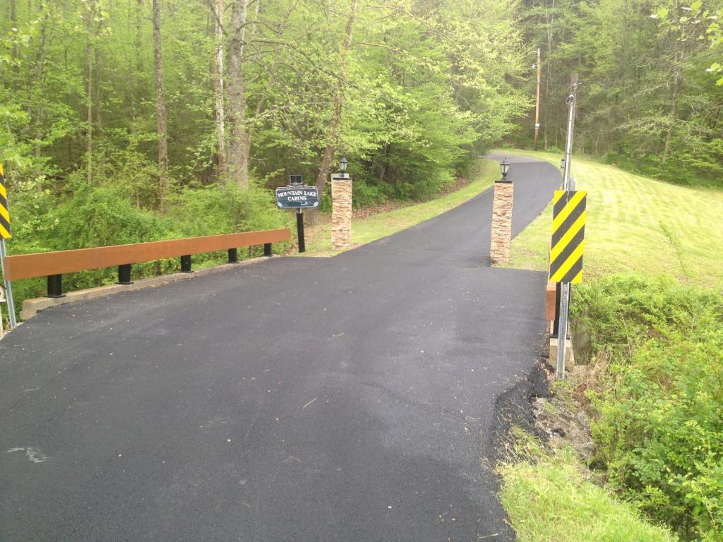 The paved entrance bridge, flanked by stone lamp posts · © Trail Head
