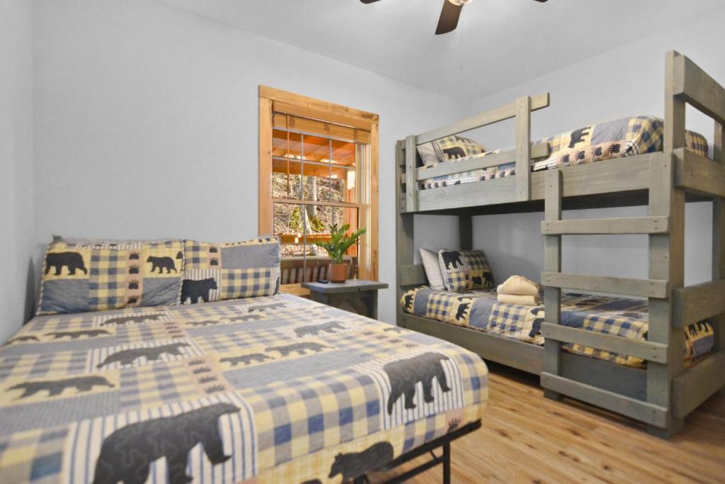 A bedroom with a bed and a set of bunks for the kids · © Tsaliwood Cabin