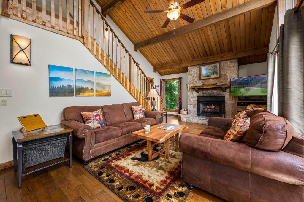 Brown sofas gathered around the stone fireplace · © Twinflower Summit