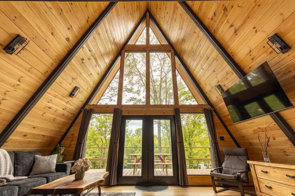 The glass gable and the deck it opens onto, framed in pine · © Valhalla Cabins