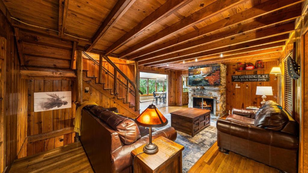 The wood-beamed living room around a stone fireplace · © Whiskey Ridge Lodge