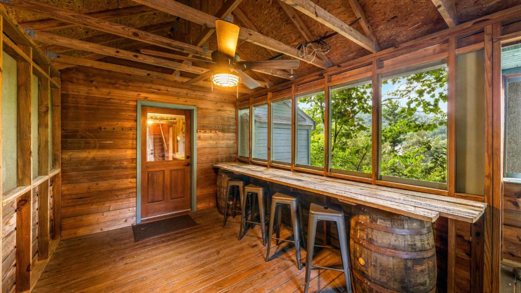 Barrel-base bar seating on the screened sky bridge · © Whiskey Ridge Lodge