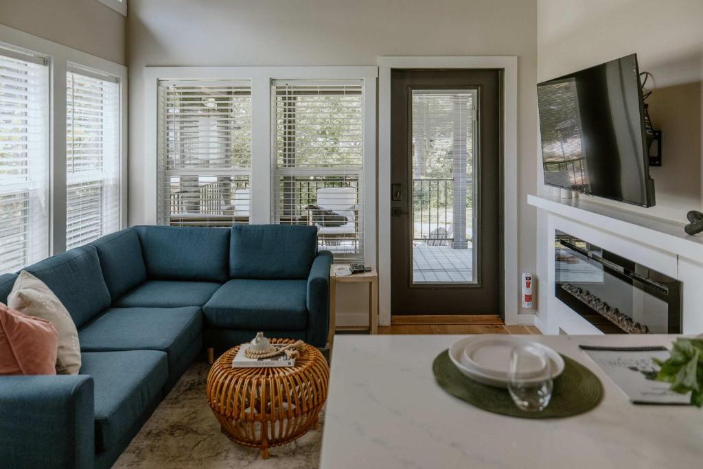 The teal sectional and electric fireplace in the main room · © Willow Cabin