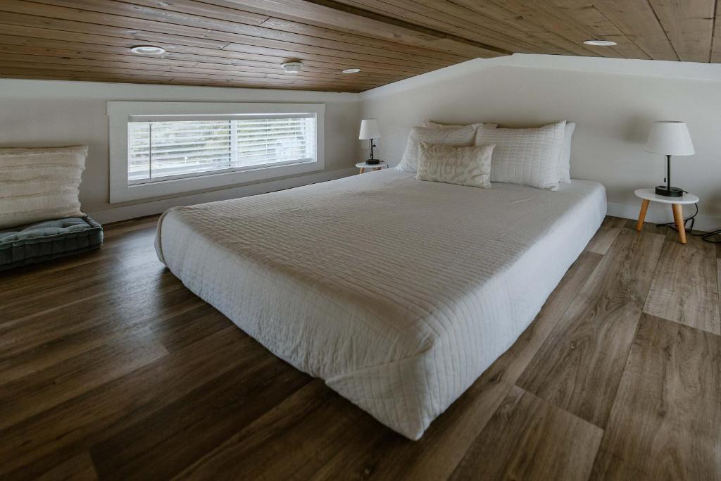 The loft bed under a low timber ceiling · © Willow Cabin