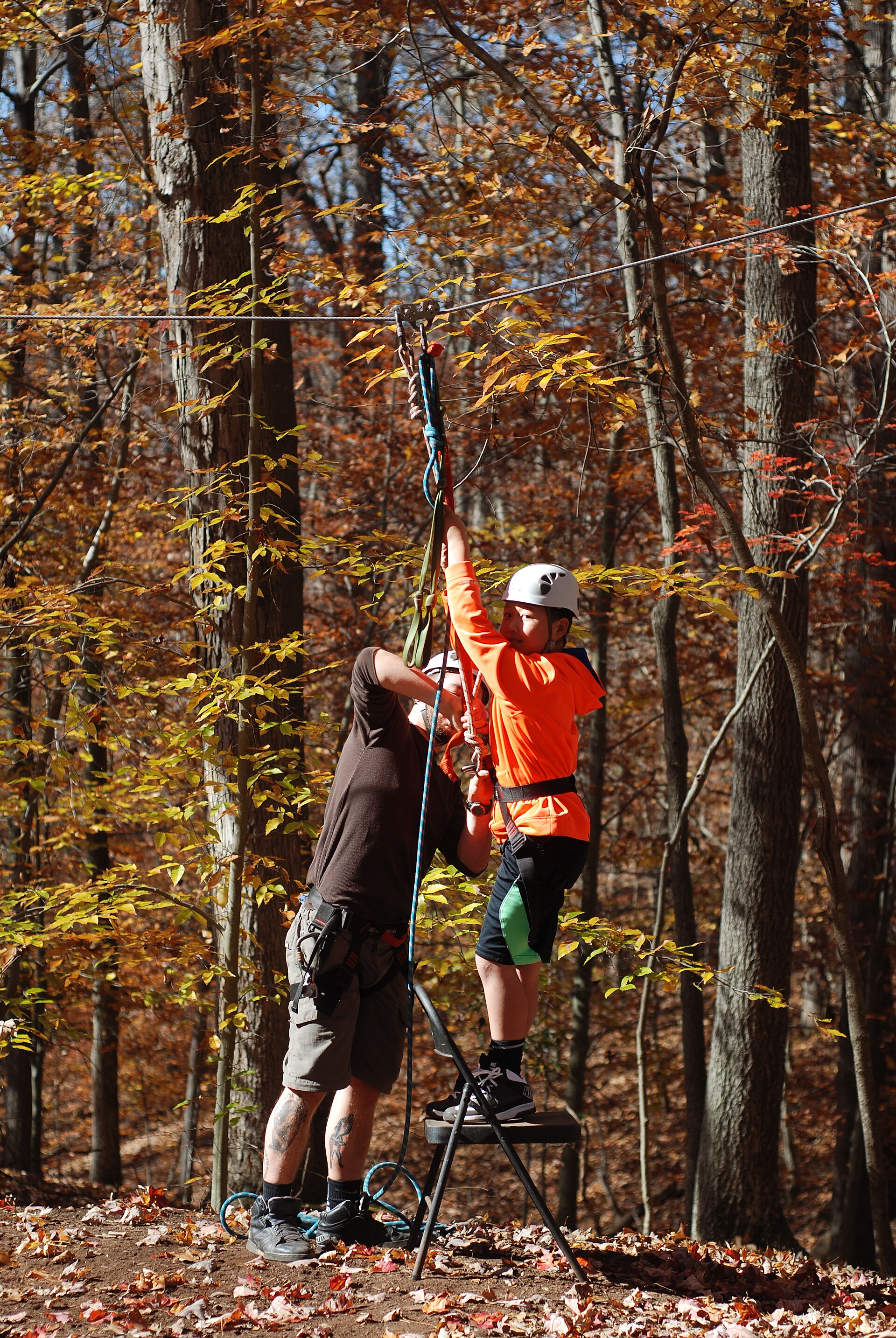 A guide clips a young rider onto the line at Hemlock Overlook, Virginia